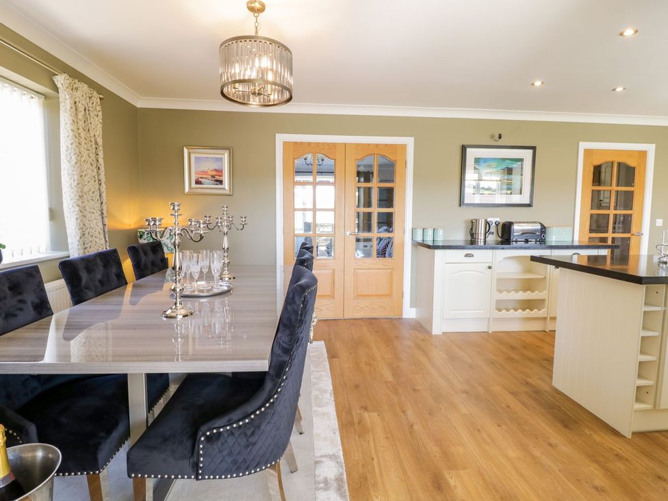 A dining room with a table and chairs at Ger Y Mor in Cemaes Bay