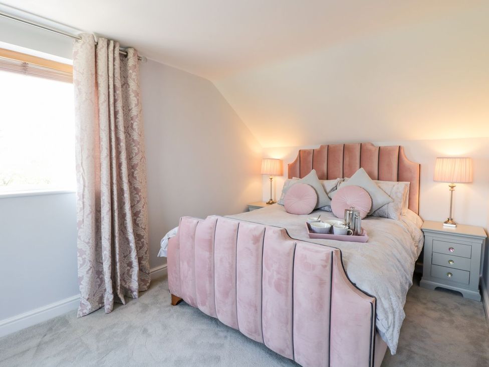 A bedroom with a bed and nightstand at Ger Y Mor in Cemaes Bay