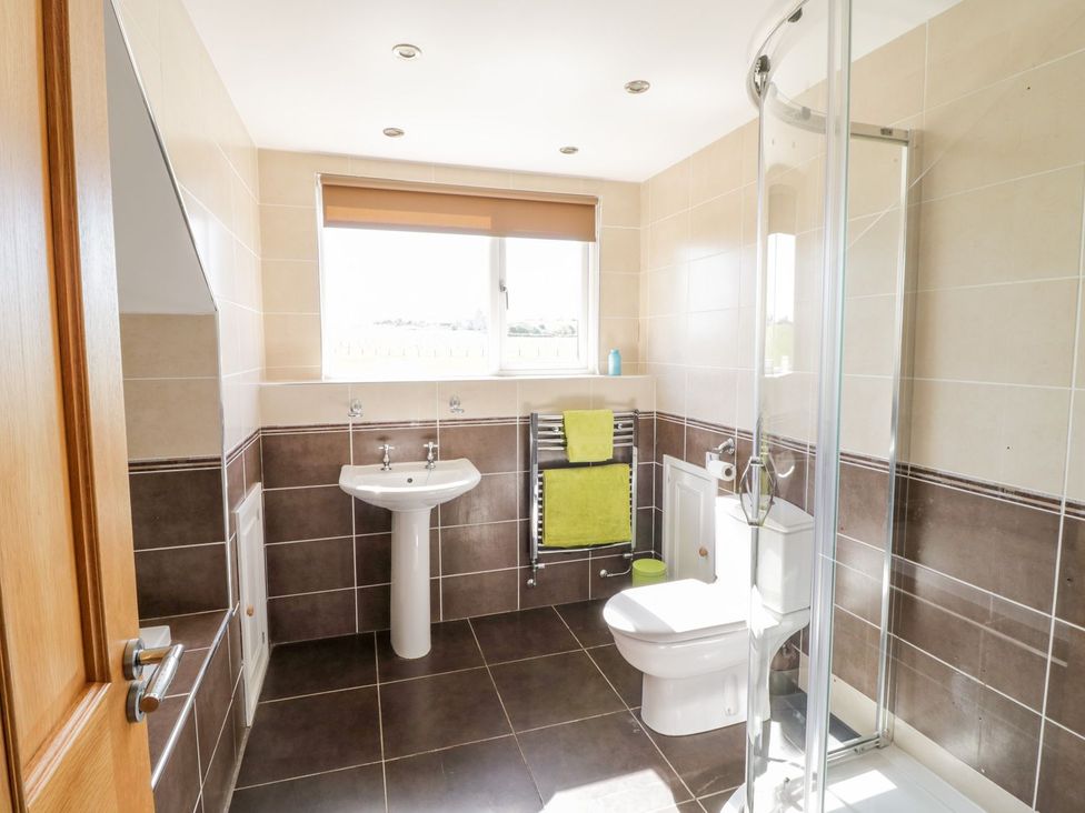 A bathroom with a shower, sink, and toilet at Ger Y Mor in Cemaes Bay