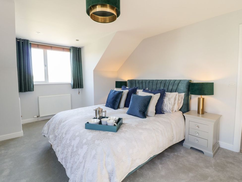 A bedroom with a bed and bedside table at Ger Y Mor in Cemaes Bay