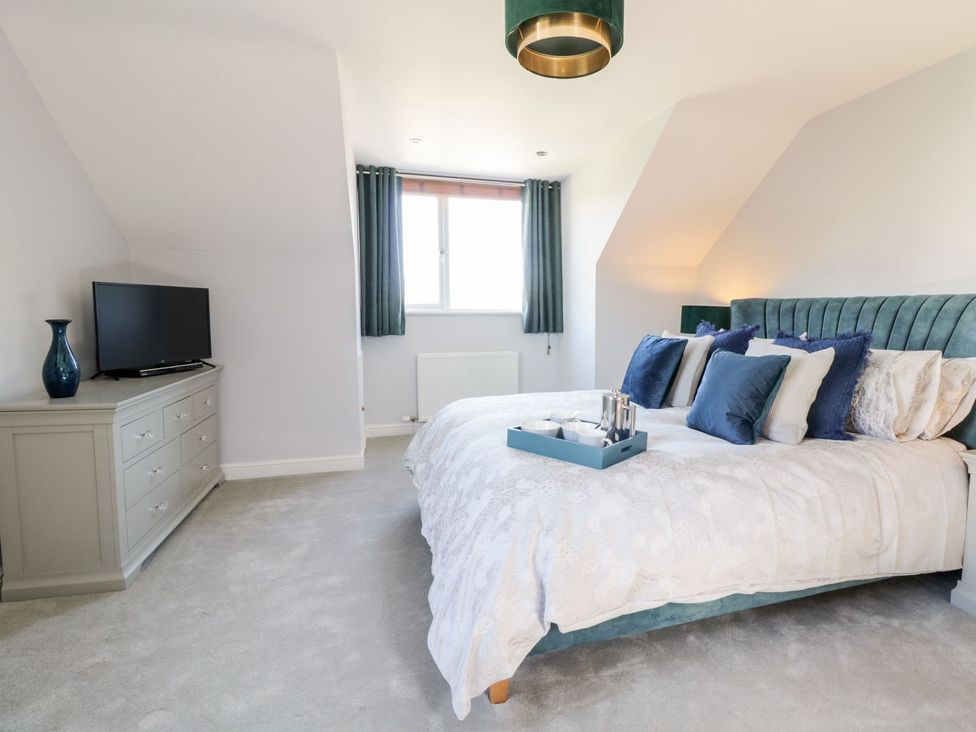 A bedroom with a bed and television at Ger Y Mor in Cemaes Bay