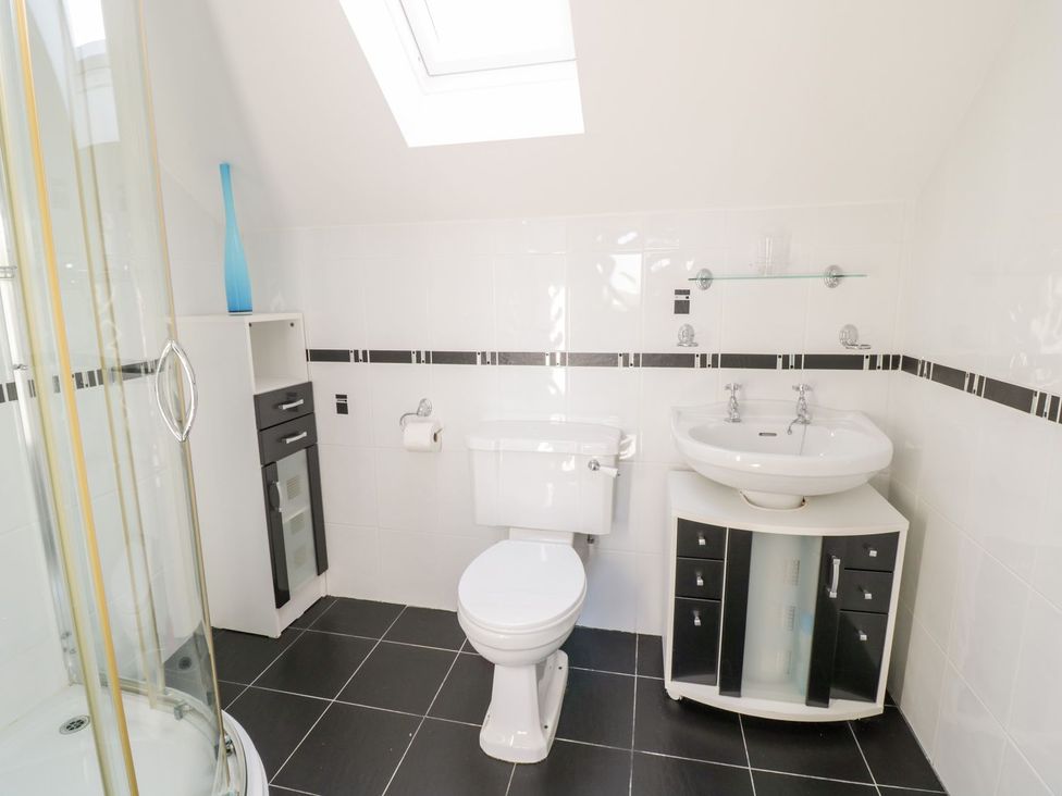 A bathroom with a shower, toilet, and sink at Ger Y Mor in Cemaes Bay