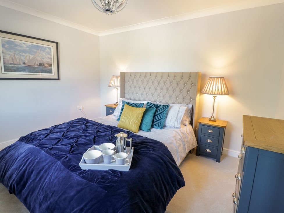 A bedroom with a bed and nightstand at Ger Y Mor in Cemaes Bay