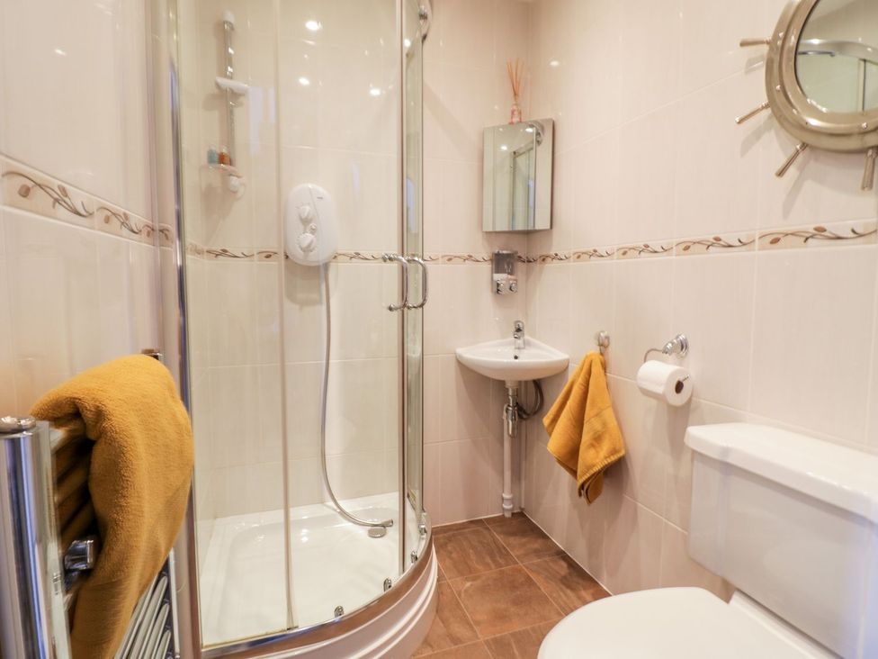 A bathroom with a shower, sink, and toilet at Ger Y Mor in Cemaes Bay