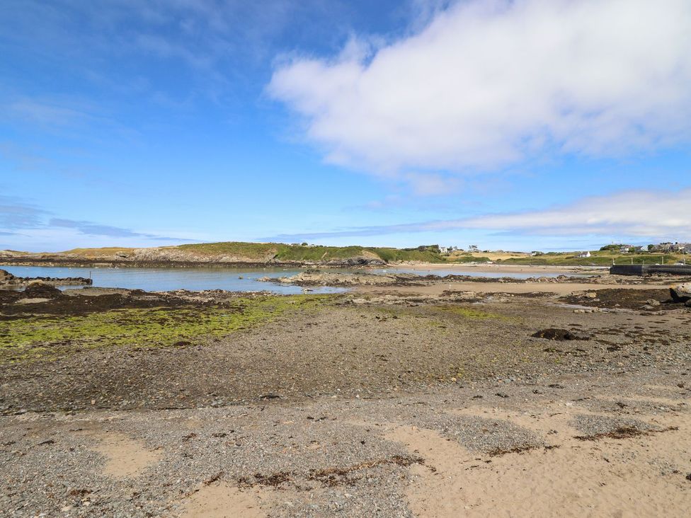 A beach with rocks and water at Ger Y Mor in Cemaes Bay