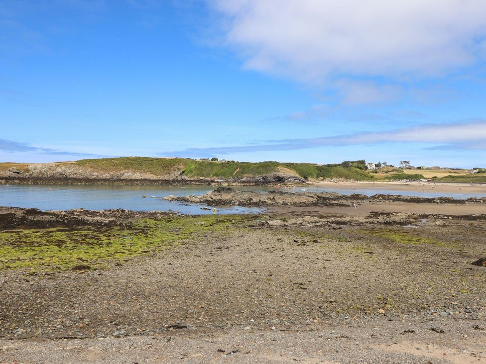 A beach with rocks and water at Ger Y Mor in Cemaes Bay