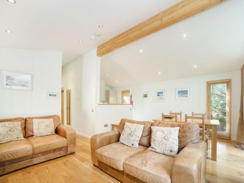 A living room with sofas and a dining area at 5 Tree Tops in Liskeard