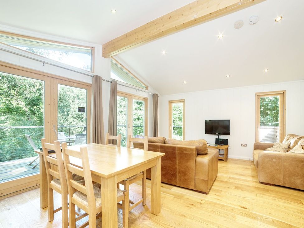 A living room with a dining table and sofa at 5 Tree Tops in Liskeard