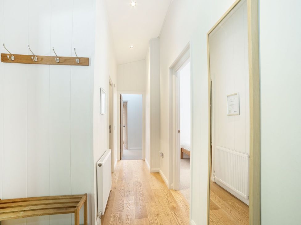 A hallway with a coat rack and mirror at 5 Tree Tops in Liskeard