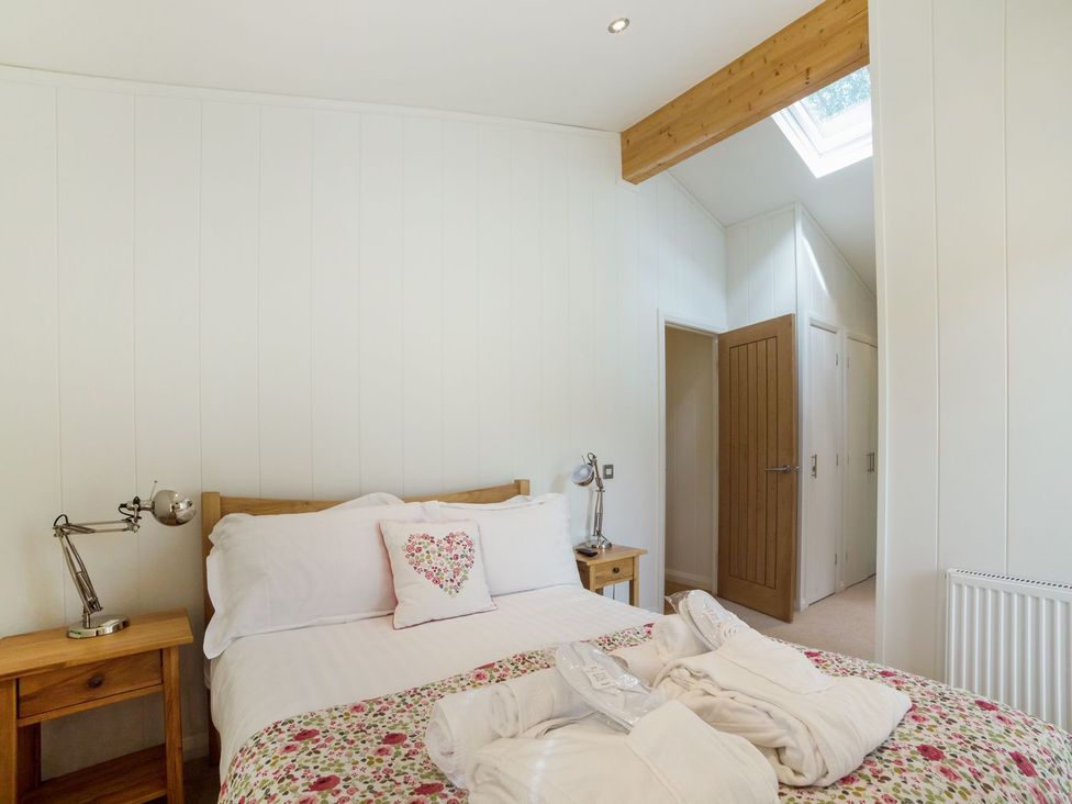 A bedroom with a bed and bedside table at 5 Tree Tops in Liskeard
