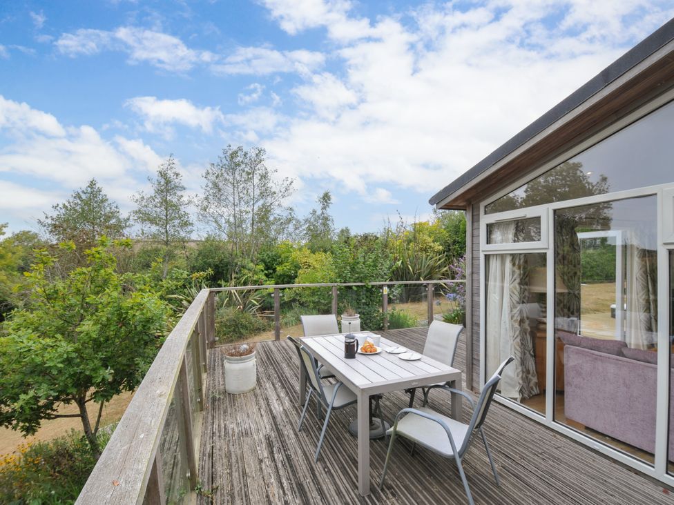 An outdoor deck with a table and chairs at 5 Tree Tops in Dobwalls