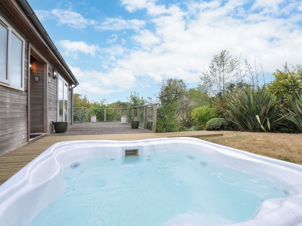 An outdoor area with a hot tub near a wooden deck at 5 Tree Tops in Dobwalls