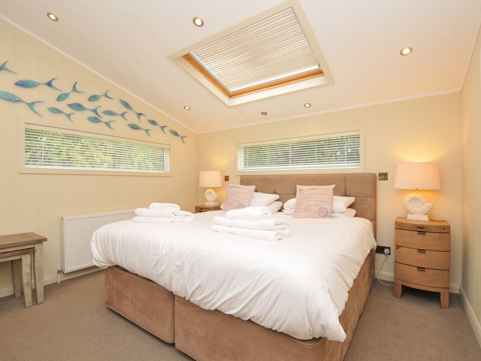 A bedroom with a double bed and fish decoration at 5 Tree Tops in Dobwalls