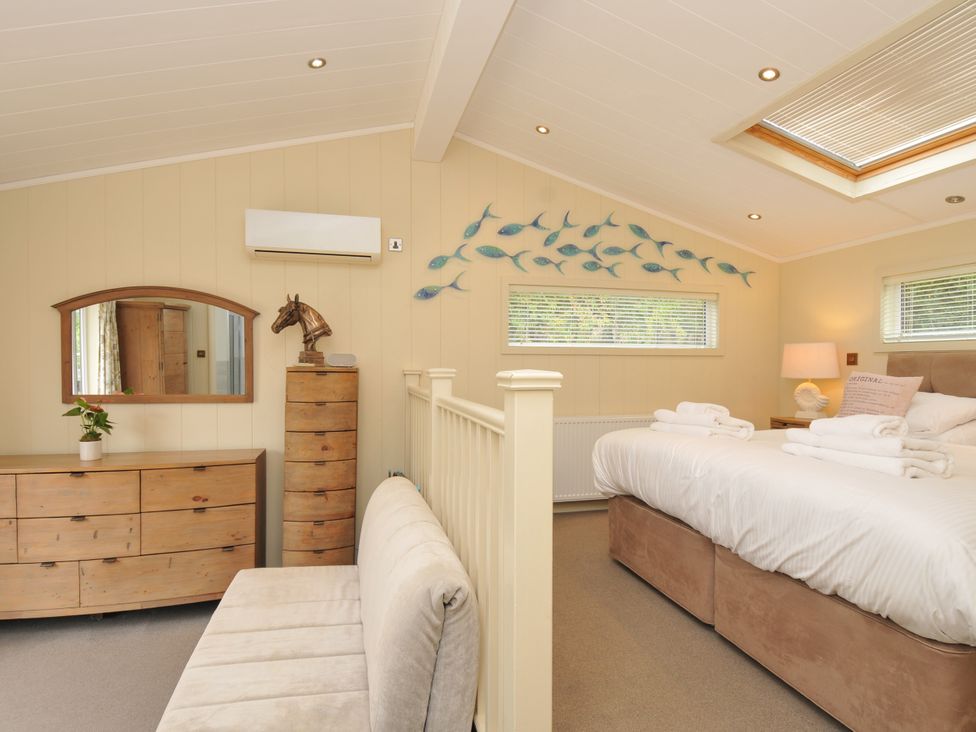 A bedroom with a bed and dressing table at 5 Tree Tops in Dobwalls