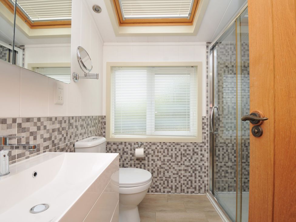 A bathroom with a sink, toilet, and shower at 5 Tree Tops in Dobwalls