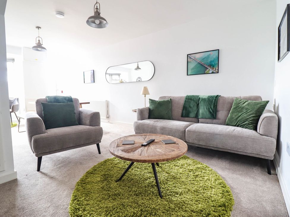 A living room with a sofa, armchair, and coffee table at 1 Glanaber Terrace