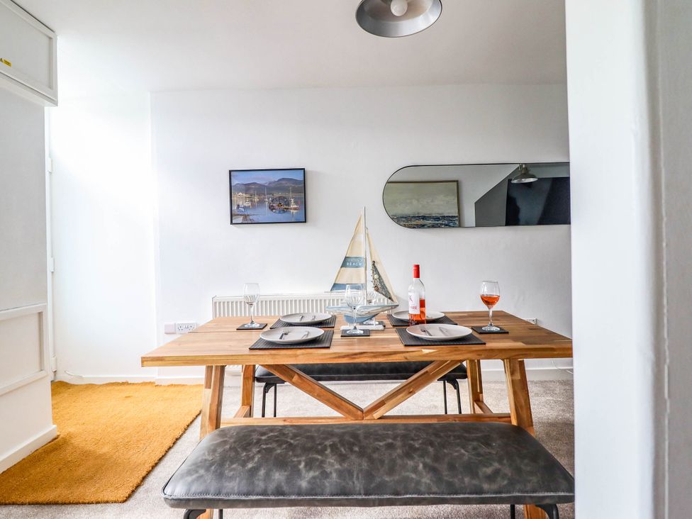 A dining room with a wooden table and wine glasses at 1 Glanaber Terrace
