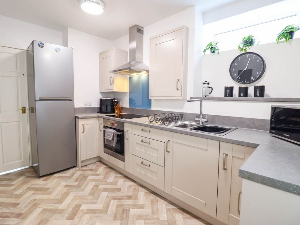 A kitchen with a refrigerator, oven, and sink at 1 Glanaber Terrace