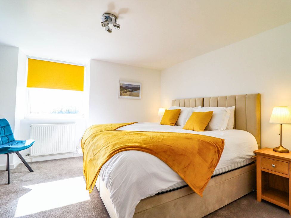 A bedroom with a bed and a chair at 1 Glanaber Terrace