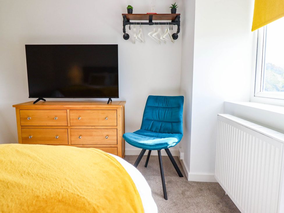 A bedroom with a television and a chair at 1 Glanaber Terrace