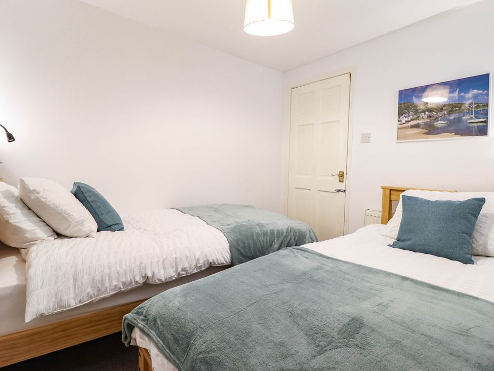 A bedroom with two beds and a picture on the wall at 1 Glanaber Terrace