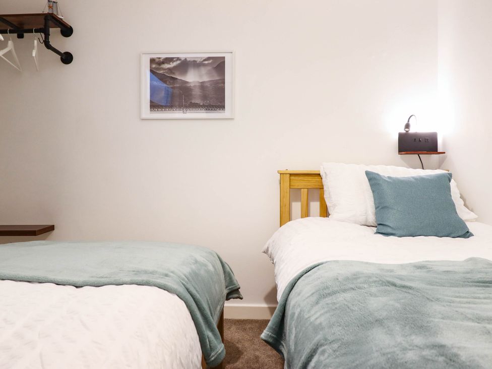 A bedroom with two beds and a shelf at 1 Glanaber Terrace
