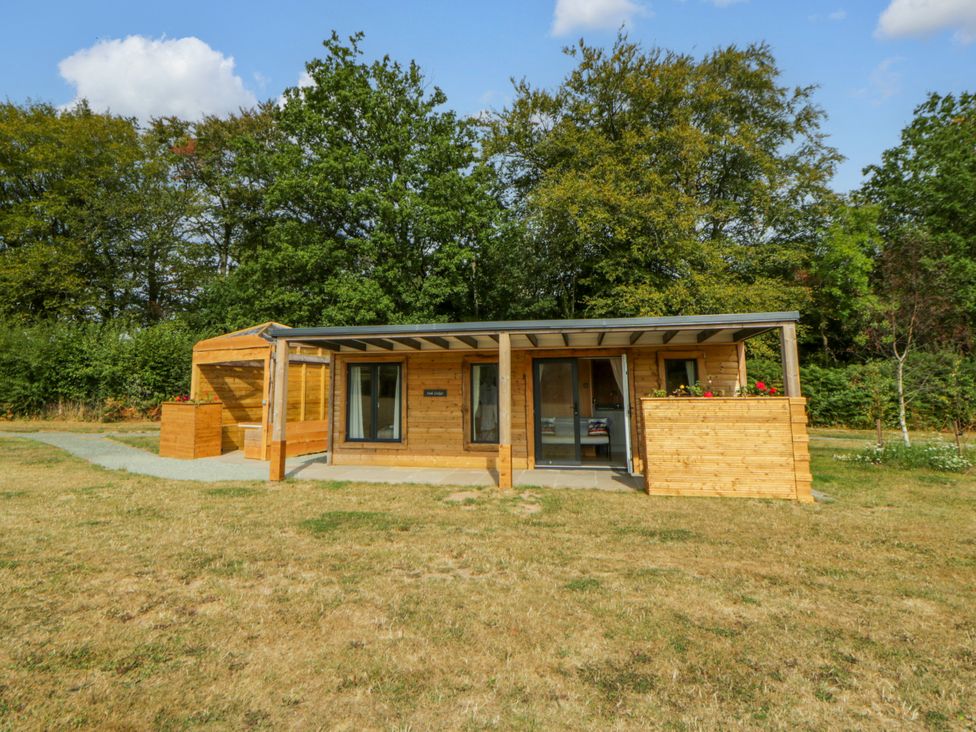 A wooden cabin with a garden area at Oak Lodge in Brecon