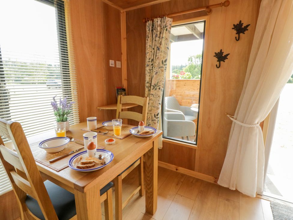 A dining room with a table set for breakfast at Oak Lodge in Brecon