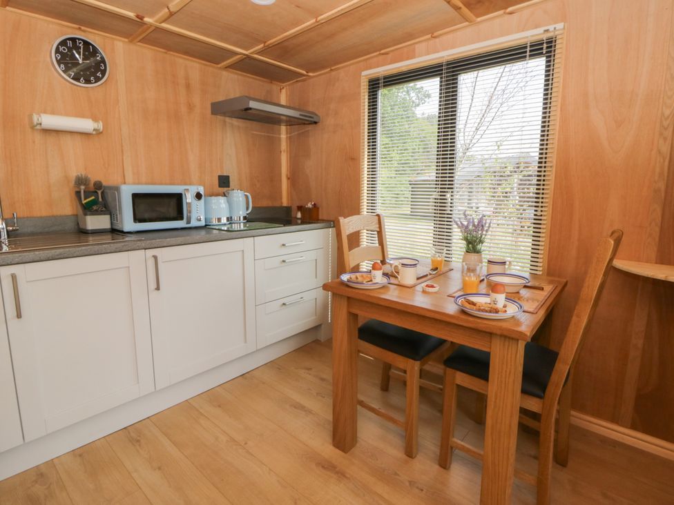 A kitchen with a dining table and chairs at Oak Lodge in Brecon