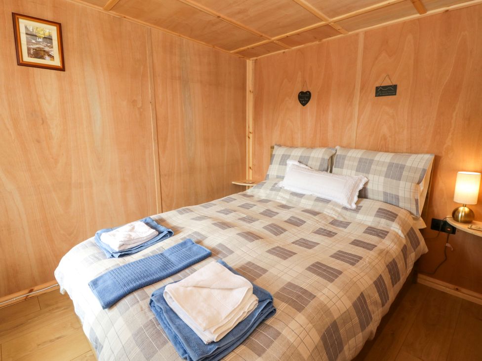 A bedroom with a bed and towels at Oak Lodge in Brecon