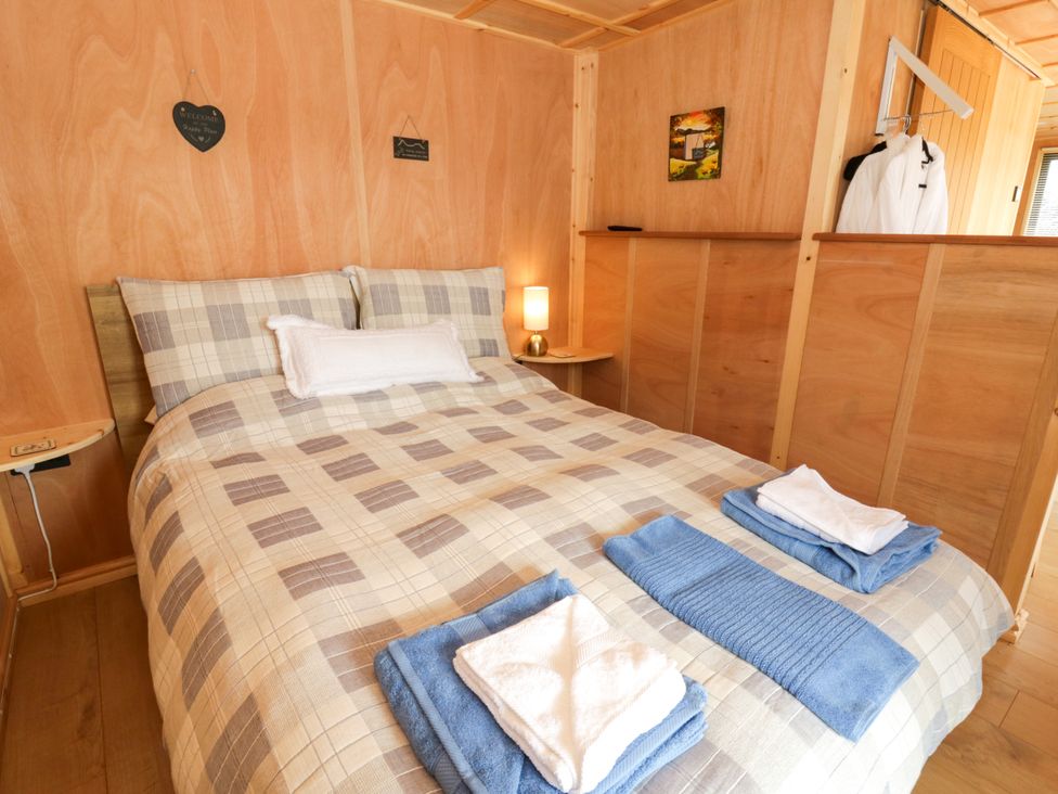 A bedroom with a bed and towels at Oak Lodge Brecon