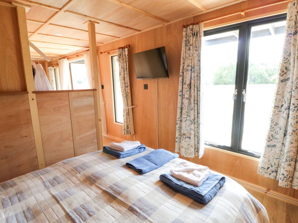 A bedroom with a bed and towels on it at Oak Lodge in Brecon