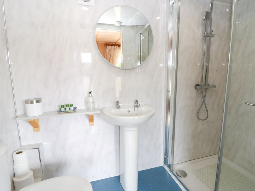 A bathroom with a sink, shower, and toilet at Oak Lodge Brecon