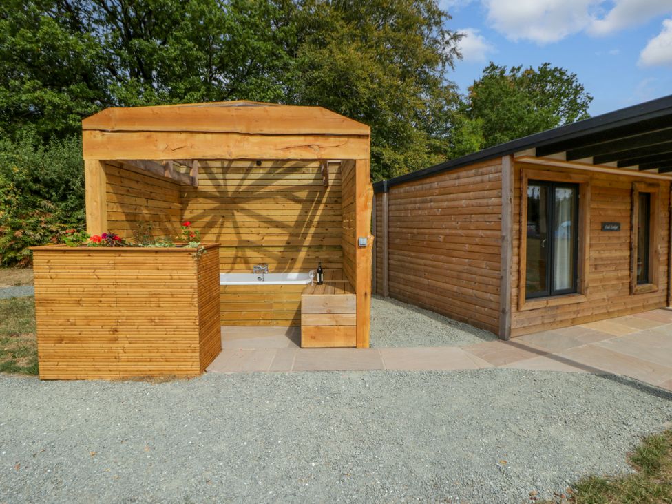 An outdoor area with a wooden bathtub structure at Oak Lodge in Brecon