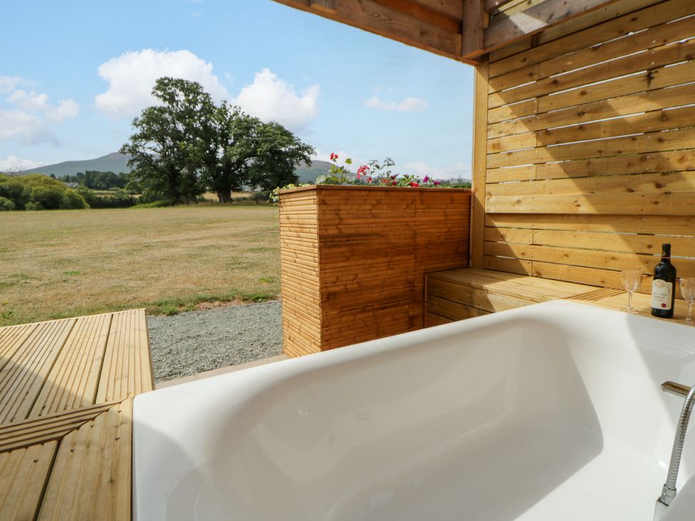 An outdoor bath area with a bathtub and wooden elements at Oak Lodge Brecon