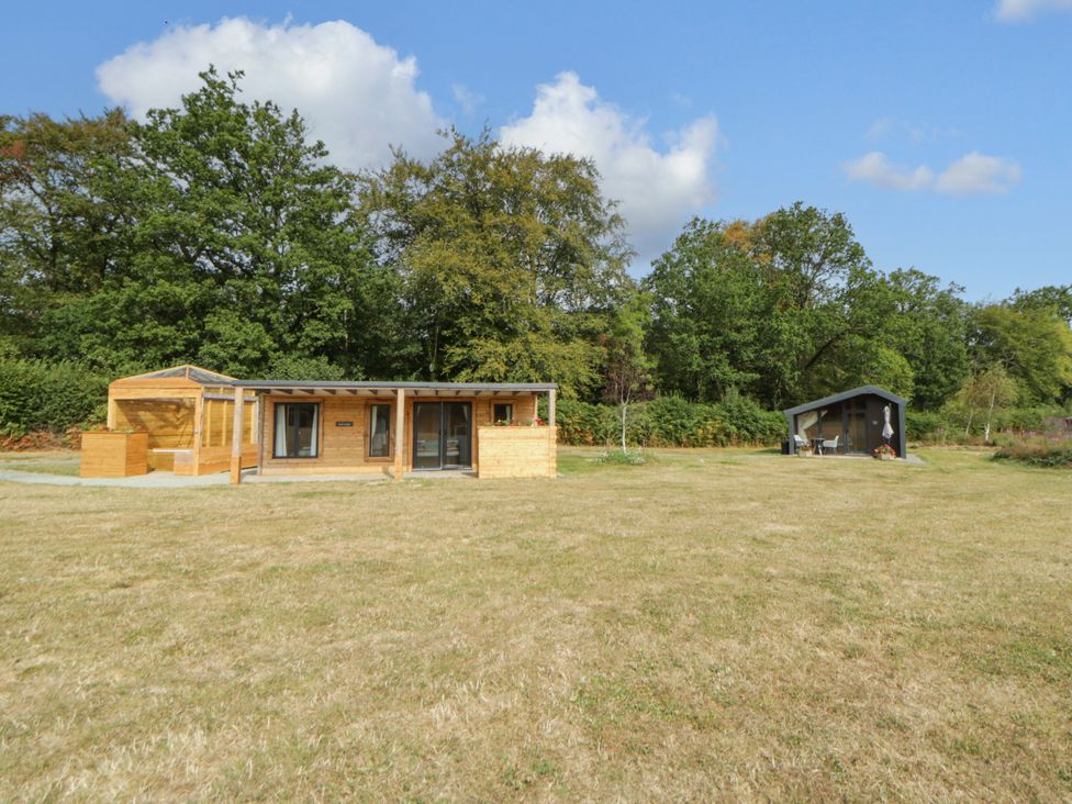 A wooden cabin and garden shed in an outdoor space at Oak Lodge Brecon