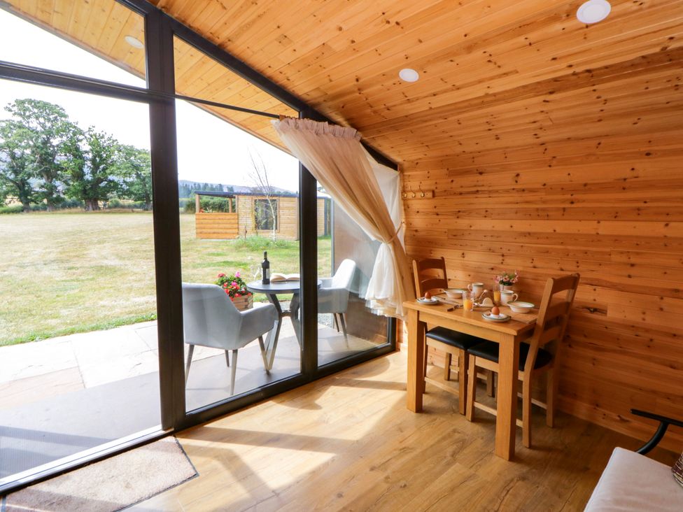 A dining room with a table and chairs at Sycamore Lodge Brecon