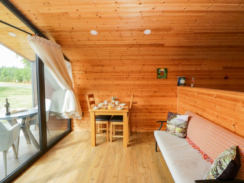 A dining area with wooden walls and a table set for a meal at Sycamore Lodge in Brecon