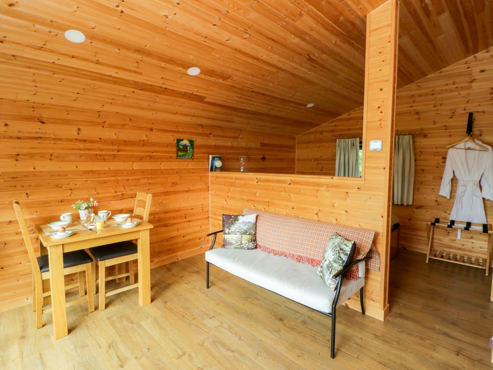 A living room with a dining table and couch at Sycamore Lodge in Brecon