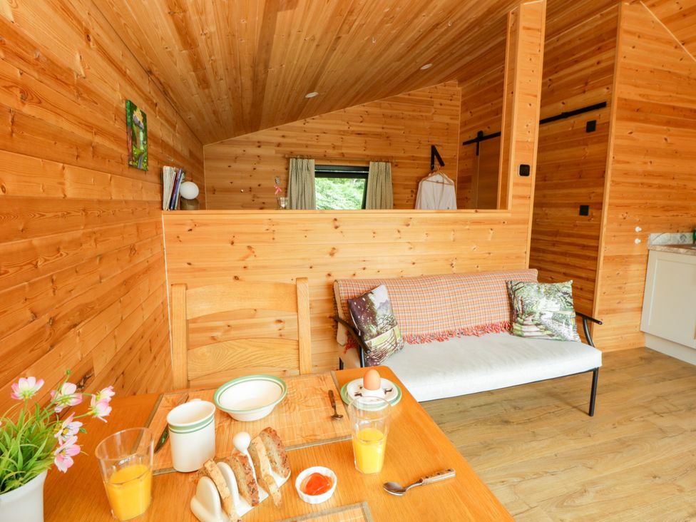 A living room with a table and breakfast items at Sycamore Lodge in Brecon