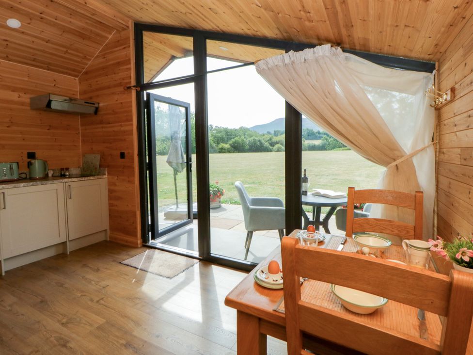 A kitchen with a table and chairs at Sycamore Lodge in Brecon