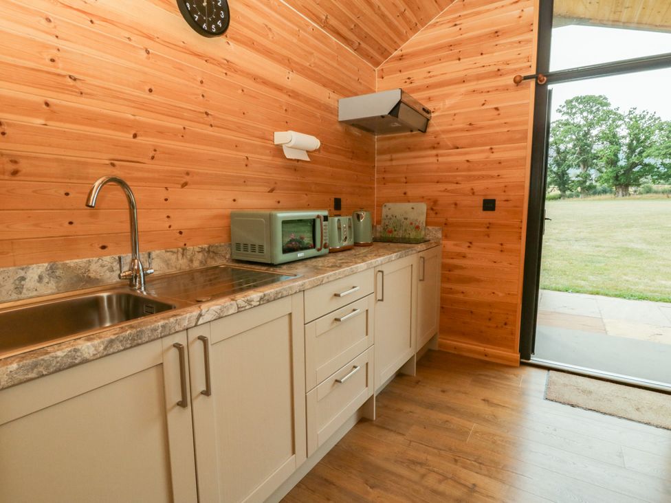 A kitchen with cabinets and appliances at Sycamore Lodge in Brecon