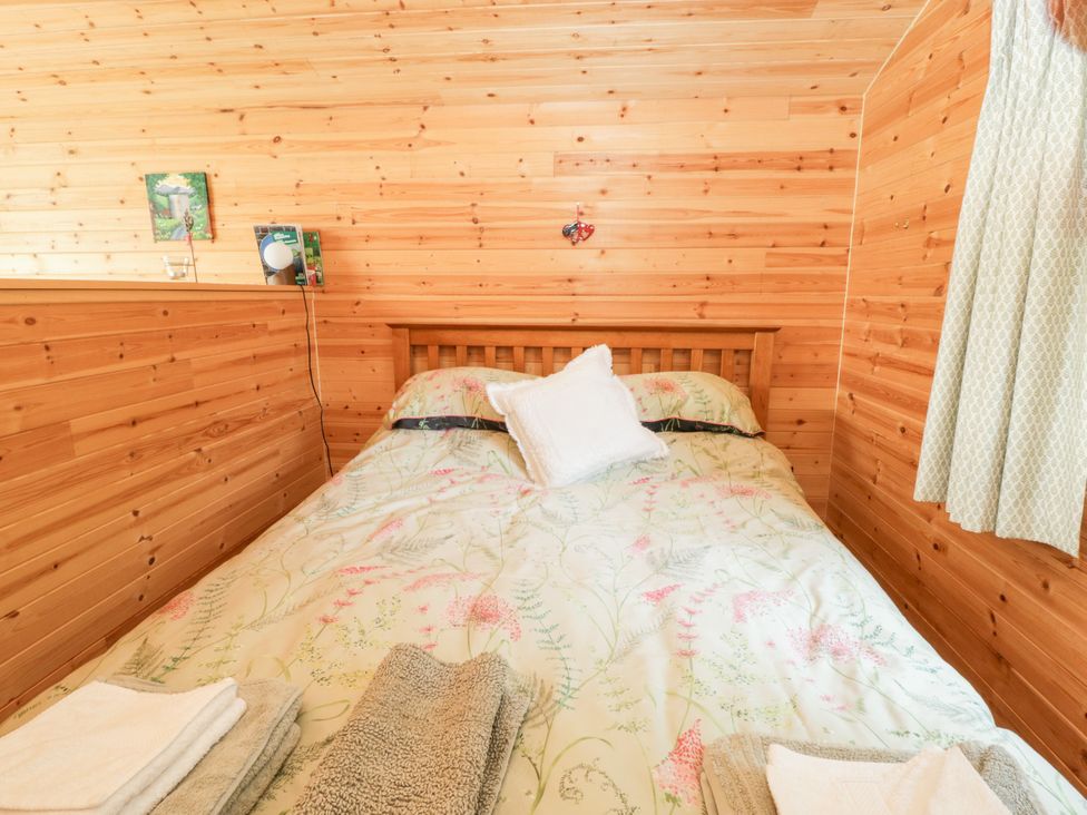 A bedroom with a bed and towels at Sycamore Lodge in Brecon