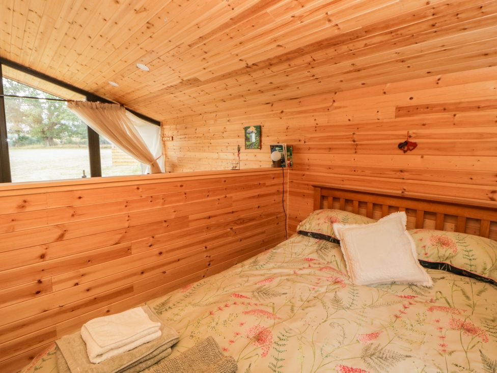 A bedroom with wood paneling and a bed at Sycamore Lodge in Brecon