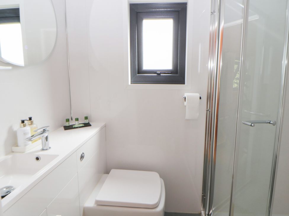 A bathroom with a washbasin, toilet, and shower at Sycamore Lodge in Brecon