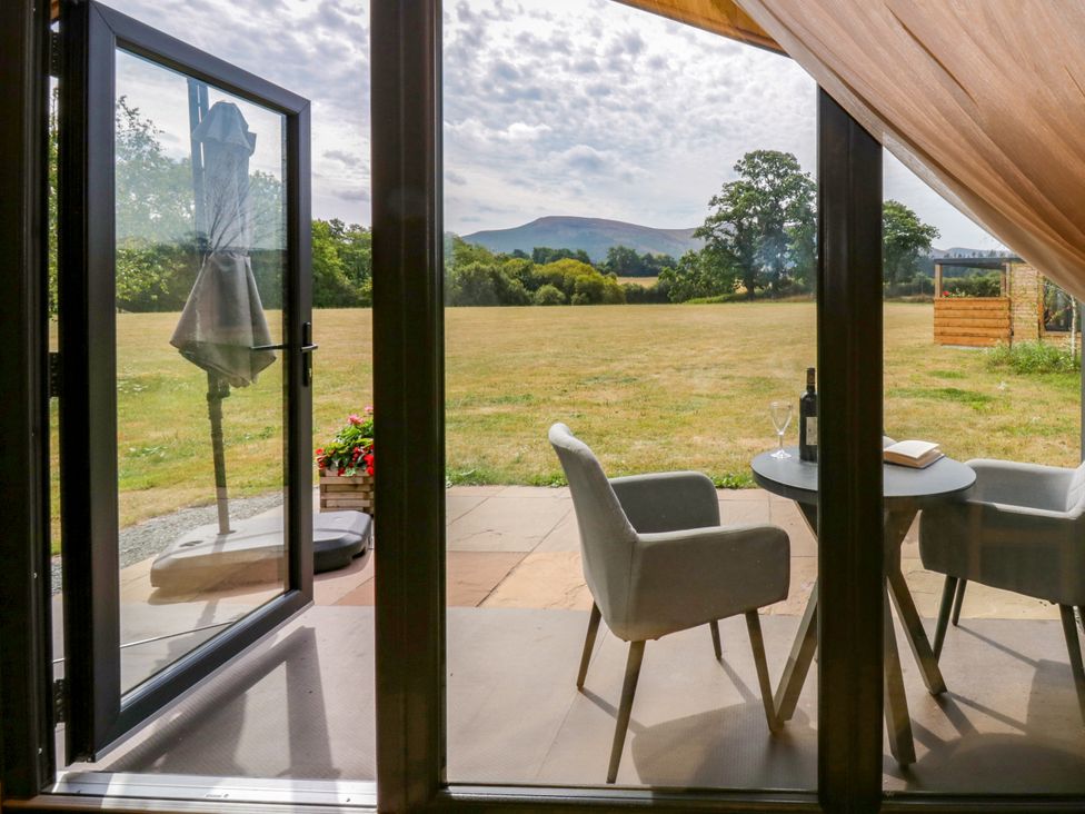 A table with chairs and a wine bottle at Sycamore Lodge Brecon