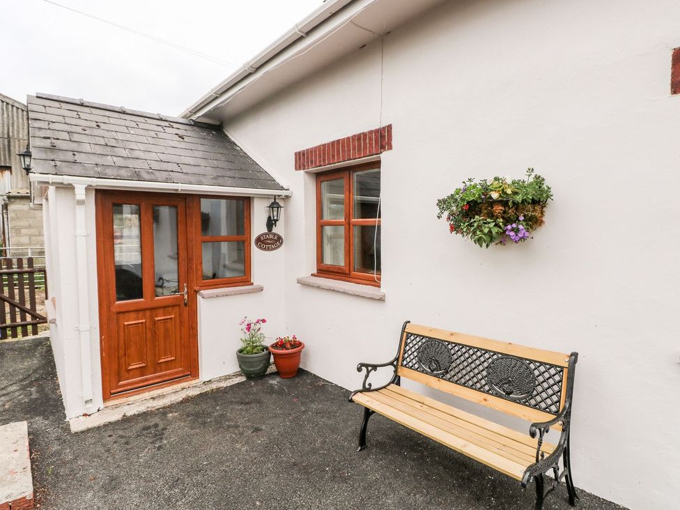 An entrance area with a bench and flowers at The Stable in Haverfordwest