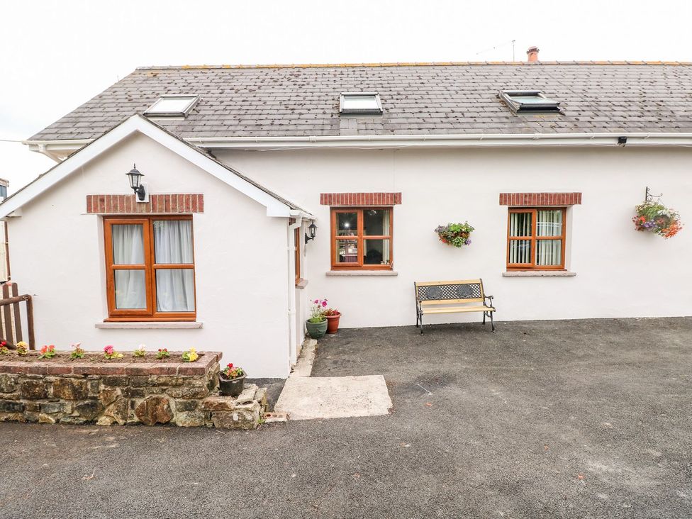 A home exterior with windows, a door, and a bench at The Stable in Haverfordwest