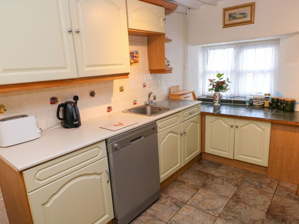 A kitchen with a kettle, toaster, sink, and flower vase at The Stable in Haverfordwest