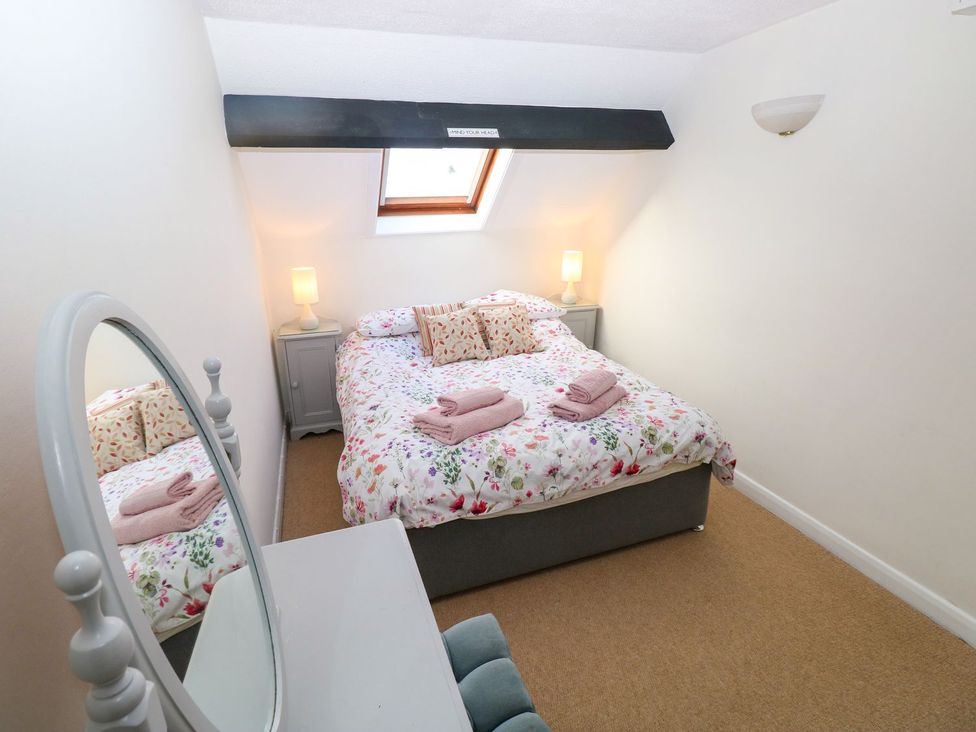 A bedroom with a bed and a mirror at The Stable Haverfordwest